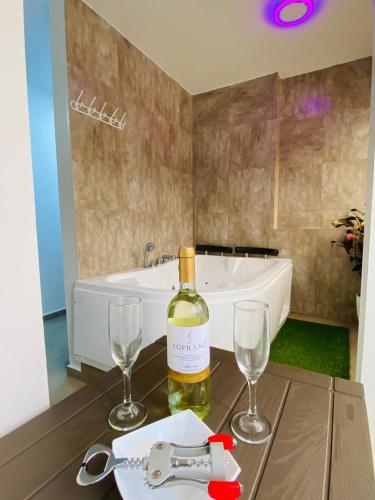 a bottle of wine and two glasses on a table at Casa Gaviota Dorada in Baños