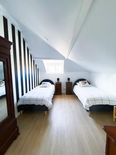 une chambre mansardée avec deux lits et une fenêtre dans l'établissement La Zingara, à Saint-Malo