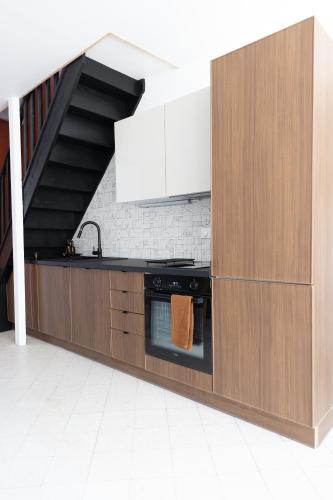 - une cuisine avec des placards en bois et une cuisinière dans l'établissement La Zingara, à Saint-Malo