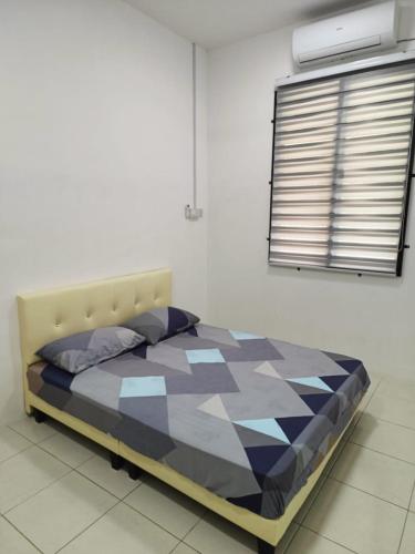 a bedroom with a bed in a room with a window at Rumah SK in Batu Kurau