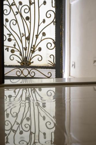 a wrought iron door with a reflection on the floor at B&B Le Stanze di Ludovica in Termoli