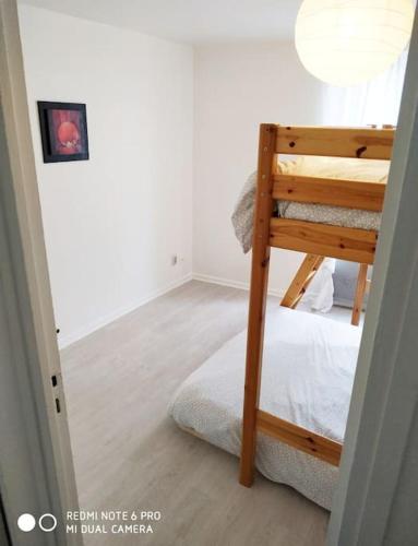 une chambre avec un lit superposé dans une pièce dans l'établissement Belle petite maison, à Montfermeil