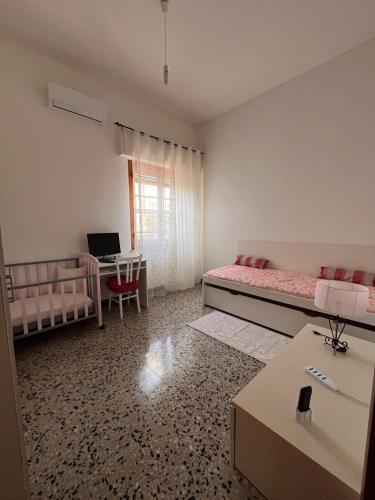 a room with two beds and a desk with a computer at Cappuccini apartments superior in Oristano