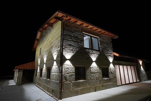 a brick building with the light shining on it at Refugio do Tempo in Beça