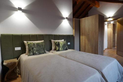 a bedroom with a large bed with two pillows at Refugio do Tempo in Beça