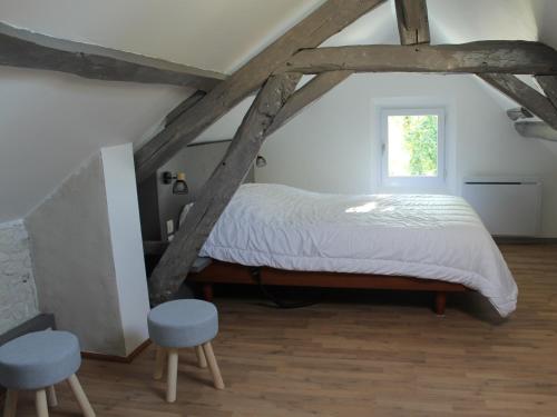 une chambre avec un lit avec deux chaises et une fenêtre dans l'établissement Maison Atypique 76m² - Centre La Roche-Posay, Terrasse, Jardin Clôturé - FR-1-541-60, à La Roche-Posay