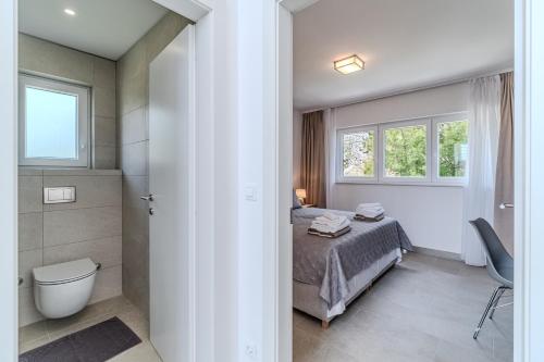 ein Schlafzimmer mit einem Bett, einer Dusche und einem WC in der Unterkunft Villa Blue Horizon in Nerežišće