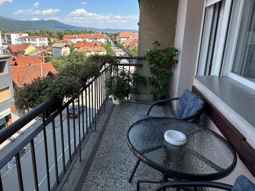 a table and chairs on a balcony with a view at Apartman Rada in Pirot