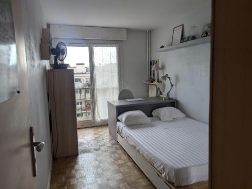 une petite chambre avec un lit et une fenêtre dans l'établissement 2 Chambres Chez l'habitant à Paris Bercy - 2 Rooms in a Private Home in Paris Bercy, à Paris