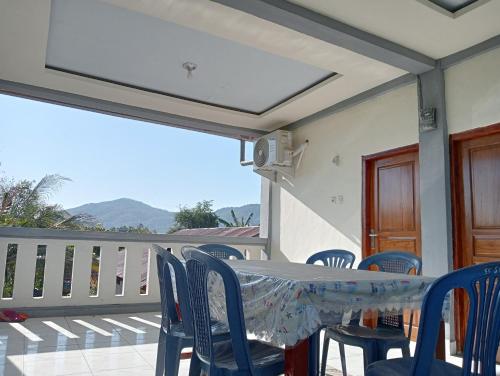 a table and chairs on a balcony with a view at Yusilver Guest House in Labuan Bajo