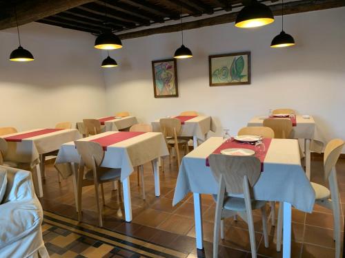 a dining room with tables and chairs and lights at El Jardín del Laurel - only adults - in Candelario