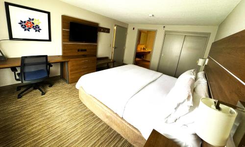a hotel room with a bed and a desk with a computer at Holiday Inn Express & Suites - Lincoln East - White Mountains by IHG in Lincoln