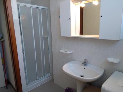 a white bathroom with a sink and a shower at Casa Martini in Lido degli Estensi