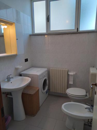a bathroom with a washing machine and a sink at Casa Martini in Lido degli Estensi