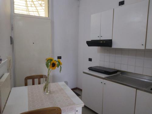 a kitchen with a vase of flowers on a table at Casa Martini in Lido degli Estensi