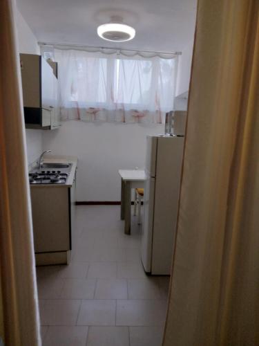 a small kitchen with a stove and a refrigerator at Casa Martini in Lido degli Estensi