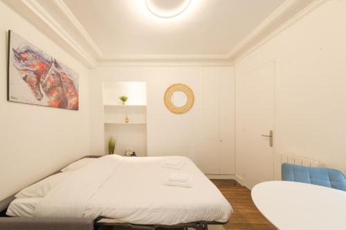 - une chambre blanche avec un lit et une chaise bleue dans l'établissement Mgic Apartment 4p Montmartre, à Paris