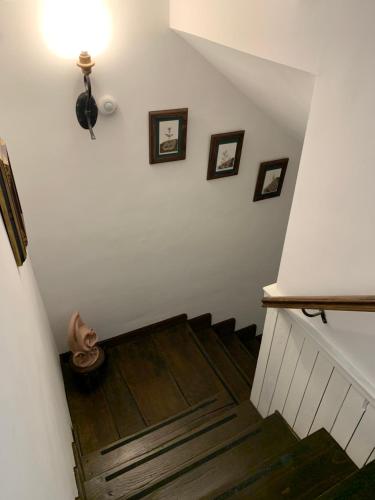 a hallway with a staircase with wooden floors and pictures on the wall at El Jardín del Laurel - only adults - in Candelario