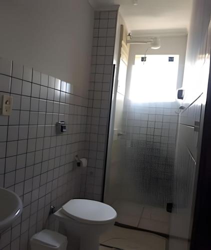 a bathroom with a toilet and a shower with a window at AP. 10 DO CANTINHO DO SOSSEGO in Dourados