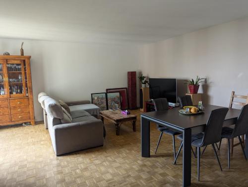 un salon avec une table et un canapé dans l'établissement 2 Chambres Chez l'habitant à Paris Bercy - 2 Rooms in a Private Home in Paris Bercy, à Paris