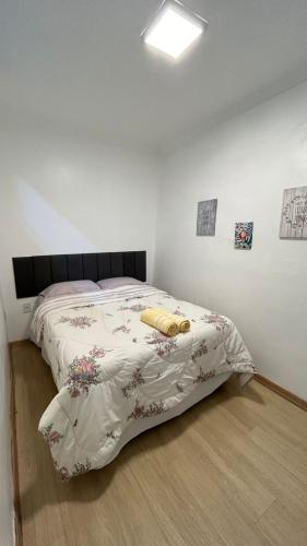 a bedroom with a bed with a comforter on it at Casa em Petropolis 7 min do Museu in Petrópolis