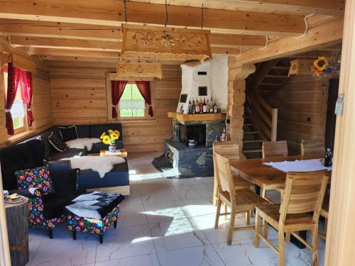 a living room with a fireplace in a log cabin at Chata Trzy Wierchy in Wisła