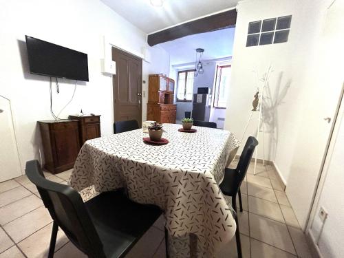 une table à manger avec des chaises et un tissu de table blanc dans l'établissement Appartement F3 charmant au cœur de Collioure, à 2 pas de la plage et des commerces - FR-1-309-284, à Collioure