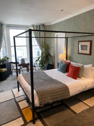 a bedroom with a four poster bed with colorful pillows at ParkRoyal Blackpool in Blackpool