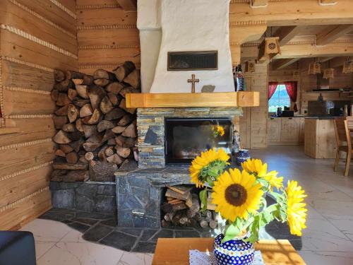 a living room with a fireplace with a tv and sunflowers at Chata Trzy Wierchy in Wisła