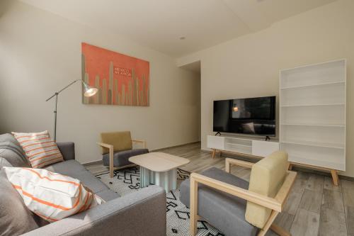 a living room with a couch and a tv at Polanco Prime Location Suites - Near USA Embassy & Citibanamex in Mexico City
