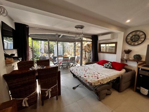 une chambre avec un lit, une table et des chaises dans l'établissement Superbe appartement 2 pièces avec piscine et parking, proche de la mer, à Villeneuve-Loubet