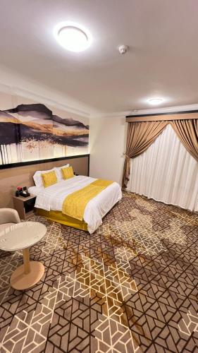 a bedroom with a bed and a table in it at فندق كابيتال جيست Capital Guest hotel in Mecca