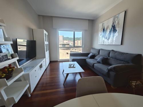 een woonkamer met een bank en een tv bij 2 habitaciones en piso Bilbao in Bilbao