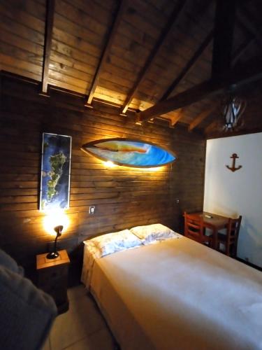 a bedroom with a large bed and a lamp at Long Life Campeche-Pousada in Florianópolis