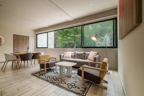 a living room with a couch and a table and chairs at Polanco Prime Location Suites - Near USA Embassy & Citibanamex in Mexico City