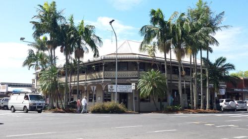 a building with palm trees in front of a street at The Middle Pub in Mullumbimby