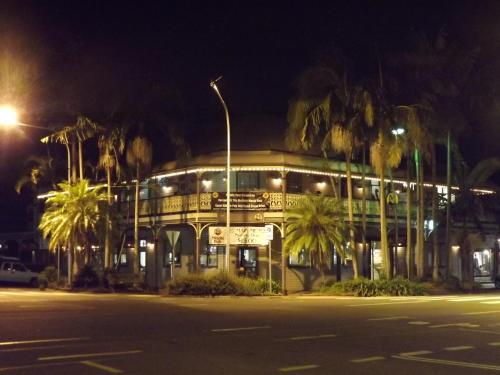 a building with a street light and palm trees at night at The Middle Pub in Mullumbimby
