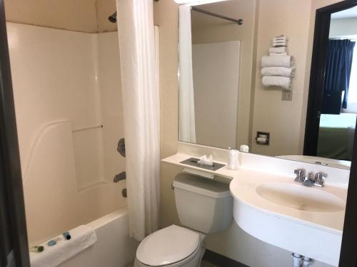 a bathroom with a toilet and a sink and a mirror at Chadron Inn & Suites in Chadron