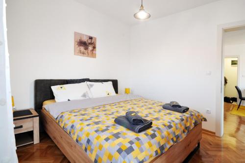 a bedroom with a bed with two pairs of shoes on it at Apartman Chaplin in Vrnjačka Banja
