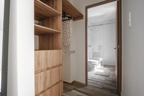 a bathroom with a wooden door and a toilet at Polanco Prime Location Suites - Near Citibanamex in Mexico City