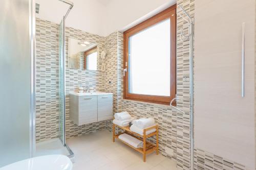 a bathroom with a glass shower and a sink at Unplug in Quartu SantʼElena