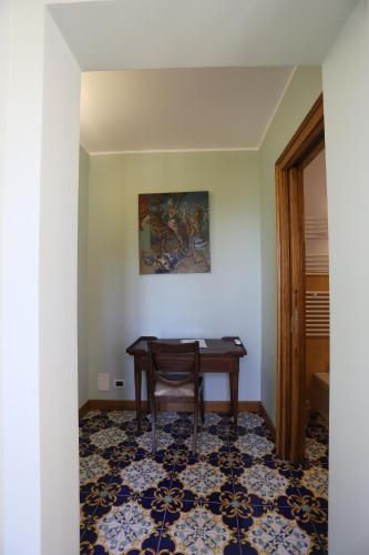 a room with a table and a chair in a room at Casa Cuseni, Patrimonio Culturale Immateriale UNESCO in Taormina