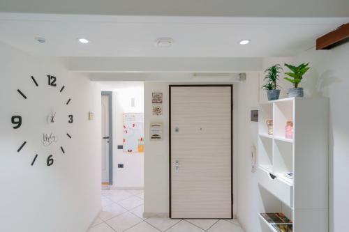 a hallway with a door and a clock on the wall at Unplug in Quartu SantʼElena
