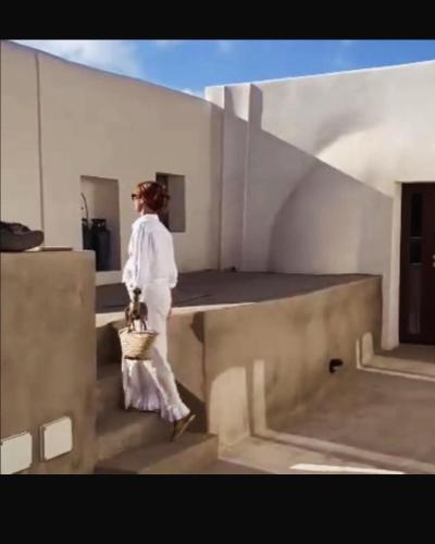 a woman walking up some stairs with a basket at La Grotta di benikula' in Pantelleria