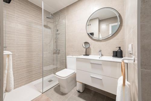a bathroom with a toilet and a sink and a mirror at Vivienda Las Arecas - El Médano in El Médano