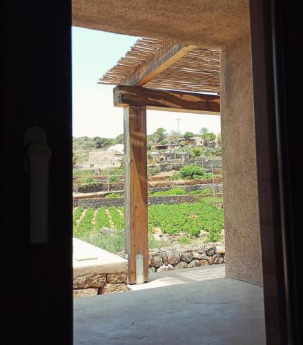 an open doorway of a house with a view of a field at La Grotta di benikula' in Pantelleria