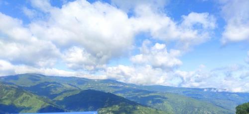 a view of a mountain range with clouds in the sky at Mayel lee in Sukhia Pokhari