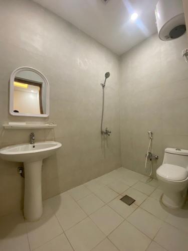 a bathroom with a sink and a toilet and a mirror at قصر أباهي للوحدات السكنية المفروشة in Al Nairyah