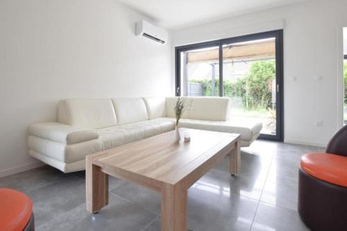 un salon avec un canapé et une table basse dans l'établissement La Villa Caennaise II, à Grentheville