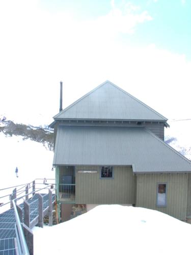 a building with a metal roof and a fence at Gotcha in Mount Hotham